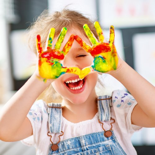 Mädchen mit Fingerfarben auf den Händen 