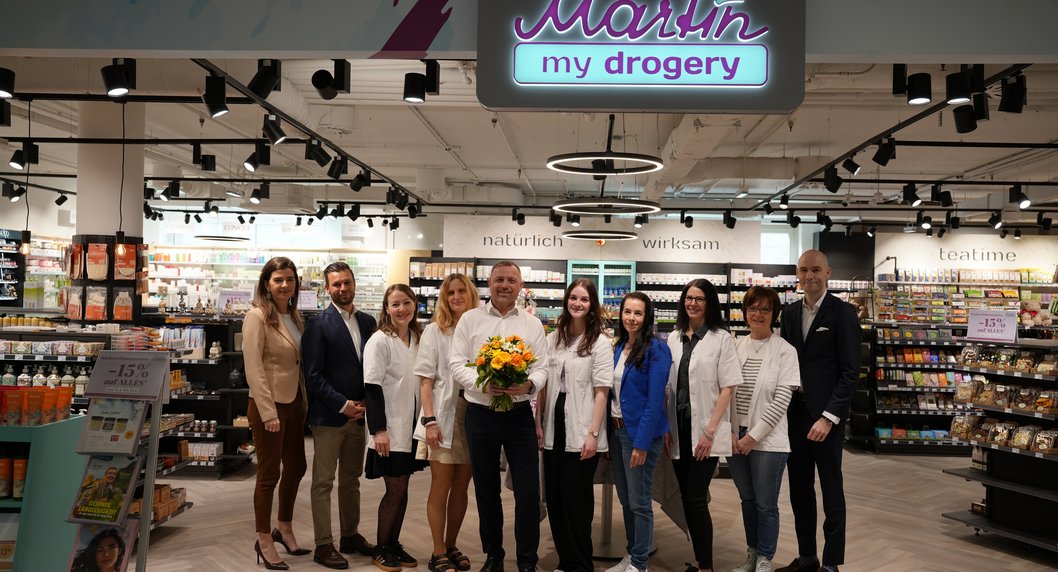 Gruppe von Menschen mit Blumenstrauß bei der Eröffnung von Martin my drogery