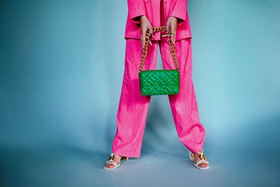 Frau bei der man nur die Beine sieht mit Handtasche in der Hand